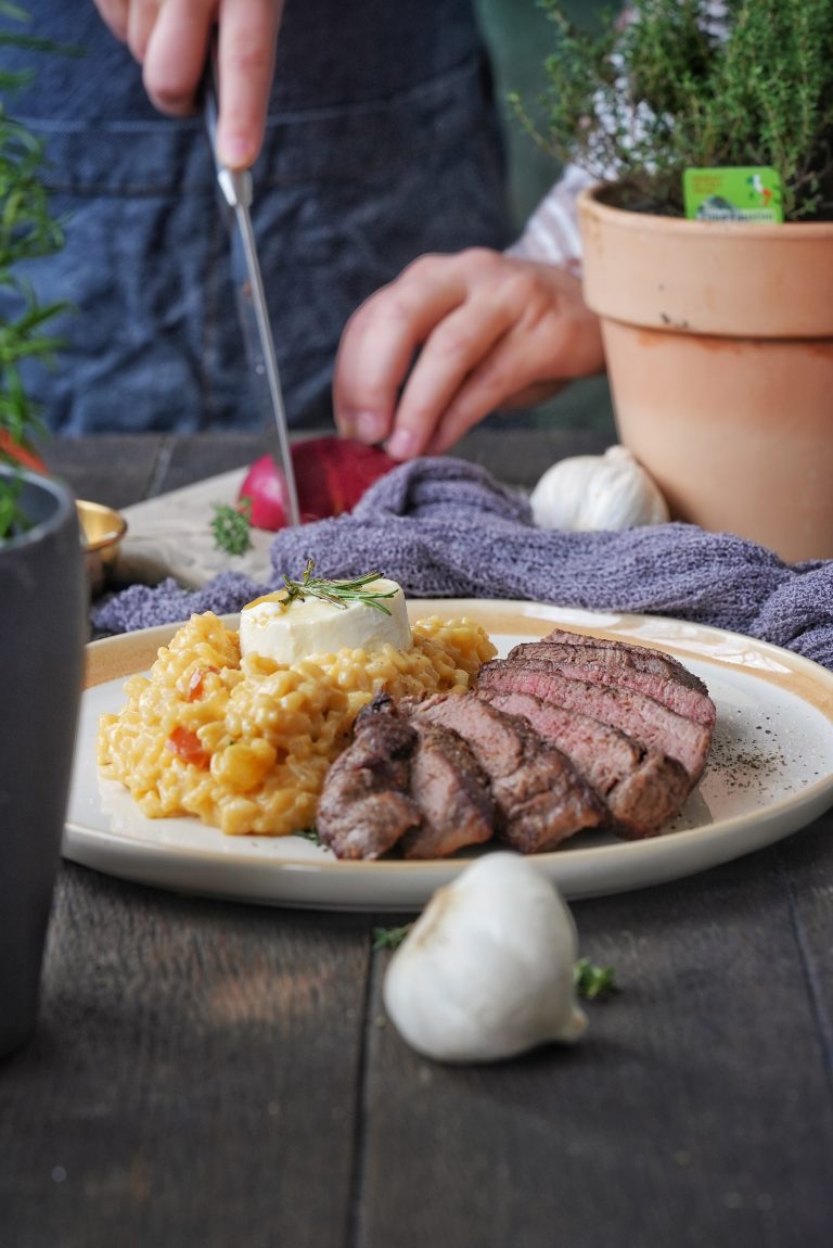 Der Weg zum perfekten Steak – Alles, was du wissen musst! Ein saftiges, zartes Steak ist für viele der kulinarische Höhepunkt eines guten Essens. Doch die Zubereitung will gelernt sein! In diesem Blogbeitrag tauchen wir in die Welt des Steaks ein: Wir erklären, wo welches Stück sitzt, welche Vorteile die verschiedenen Cuts haben, und geben Tipps zu Garstufen und Zubereitung. Am Ende erwartet dich ein Rezept für das perfekte Steak, kombiniert mit einem cremigen Kürbisrisotto. Die wichtigsten Steak-Cuts und ihre Eigenschaften Filet (Tenderloin) Lage: Aus dem Lendenbereich, nahe der Wirbelsäule. Merkmale: Extrem zart, da der Muskel wenig beansprucht wird. Vorteile: Ideal für feine Gerichte, schmeckt pur oder mit milden Saucen. Garstufe: Perfekt bei medium-rare. Ribeye Lage: Aus dem vorderen Rücken, zwischen den Rippen. Merkmale: Stark marmoriert, saftig und aromatisch. Vorteile: Der hohe Fettgehalt sorgt für intensiven Geschmack. Garstufe: Durch die Marmorierung hervorragend bei medium. Rumpsteak (Sirloin) Lage: Vom hinteren Rücken, nahe der Hüfte. Merkmale: Fester, aber mit intensivem Geschmack. Vorteile: Universell einsetzbar, eignet sich auch für Marinaden. Garstufe: Von rare bis medium-well. T-Bone und Porterhouse Lage: Kombination aus Filet und Rumpsteak, getrennt durch den T-förmigen Knochen. Merkmale: Großzügige Portion mit zwei Texturen. Vorteile: Ideal für Grillfans. Garstufe: Optimal bei medium. Die wichtigsten Garstufen für Steak Rare (45–50 °C): Innen rot und roh, sehr saftig. Medium-Rare (50–55 °C): Innen zart rosa mit leichtem Bratenrand, perfektes Gleichgewicht. Medium (55–60 °C): Gleichmäßig rosa, fester in der Textur. Medium-Well (60–65 °C): Nur ein Hauch rosa, eher trocken. Well-Done (>65 °C): Komplett durchgebraten, oft weniger saftig. Ein Fleischthermometer ist der beste Freund eines Steakliebhabers, um die gewünschte Garstufe zu treffen!